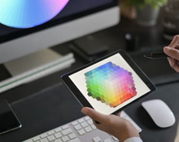 Designer wybiera kolory z palety kolorów na tablecie.